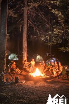 a group of people sitting around a campfire