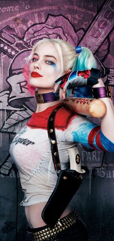 a woman dressed as harley in front of a graffiti wall with her hands on her hips