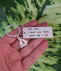 someone is holding a keychain that says, sail safe i need you here with me aa