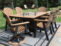 an outdoor dining table and chairs set up on a patio with grass in the background