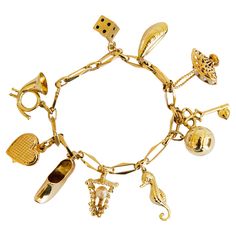 A vintage 14 karat yellow gold bracelet with 10 charms, including a hunting horn, a heart, a clog, a lantern, a seahorse, a ball, a key, a basket with five pearls, a mussel, and a dice. The bracelet was manufactured in the middle of the 20th century. Despite its age, it is in a really good condition. Please notice that the hunting horn charm has a small dent. The bracelet is absolutely a cheerful and playful eye catcher. It can be worn during daily as well as special occasions. The bracelet is the most suitable for a person with a middle- and a wider wrist. The bracelet as well as each charm were tested and are marked with the 14 karat gold marks. Measurements: length: 19 cm, width: 5 mm charms: ca. 8-35 mm weight: 29.8 grams Luxury Tarnish-resistant Metal Charm Bracelet, Classic Luxury Gold Charm Bracelet, Cheap Gold Charm Bracelet With Removable Charms, Luxury Vintage Charm Bracelet As A Gift, Cheap Vintage Gold Charm Bracelet, Vintage Gold Charm Bracelet Luxury, Cheap Bohemian Charm Bracelets With Lobster Clasp, Antique Charm Bracelet, Yellow Bracelet