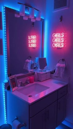 a bathroom with two neon lights on the wall and a sink in the foreground