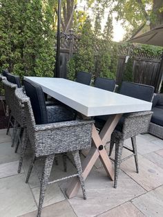 an outdoor dining table with chairs and umbrella