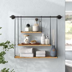 two shelves with towels, soaps and other items on them against a white wall