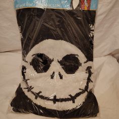 a plastic bag with a skull face on the front and bottom, sitting on a bed