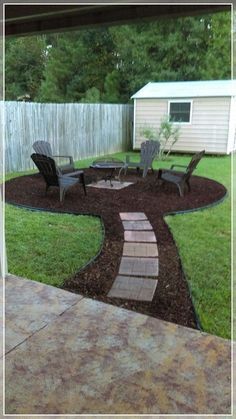 a backyard with lawn chairs and a fire pit