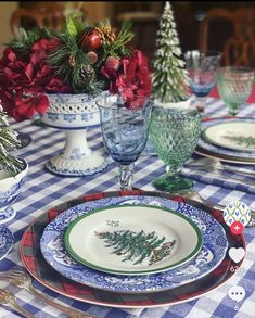 the table is set for christmas dinner with blue and white dishes