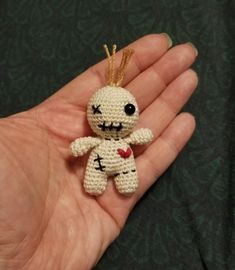 a hand holding a tiny crocheted stuffed animal