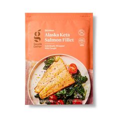 a bag of salmon fillet sitting on top of a white plate with spinach