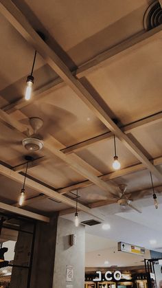 some lights are hanging from the ceiling in a room with concrete walls and exposed ceilings