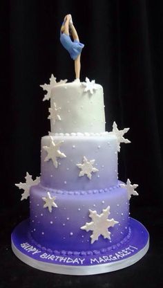 a three tiered cake decorated with stars and a girl on top is purple and white