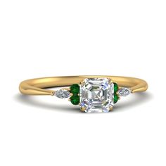 an emerald and diamond engagement ring with three diamonds on the band, set in yellow gold