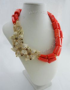 "The beauty of natural corals accented with Gold gives this necklace an authentic African traditional feel. Coral necklaces are a staple in most West-African attire, and this statement coral necklace represents just that! What You Need to Know - Handcrafted Necklace is 17-19inches length - 2 strands of Genuine Coral barrel beads - Matching pair of earrings are 3.5inches - Accented with Gold plated pendant (3 inches) - Miniature gold Czech glass beads separate coral beads - Due to natural nature Handmade Red Coral Wedding Necklace, Handmade Red Coral Necklace For Weddings, Beaded Red Coral Necklace, Coral Beaded Necklace In Red Coral, Coral Beaded Necklaces In Red Coral, Beaded Red Coral Necklaces In Coral Color, Red Coral Beaded Necklace, Spring Jewelry Trends, Statement Wedding Jewelry