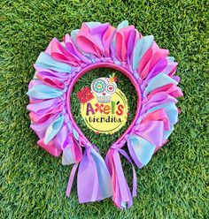 a purple and blue frisbee with an owl on it sitting in the grass