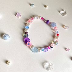 a white table topped with lots of beads and charms