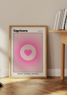 a pink poster with the word capricorn on it in front of a bookshelf