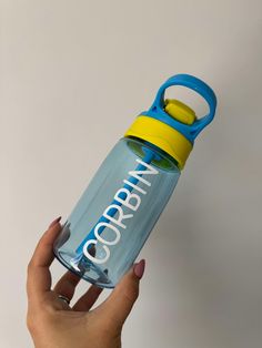 a hand holding a blue and yellow water bottle with the word gorrat printed on it