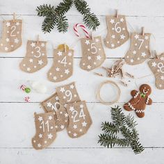 christmas stockings and ornaments are laid out on a white wooden surface with pine branches, candy canes, ornament