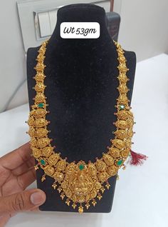 a gold necklace is displayed on a display stand