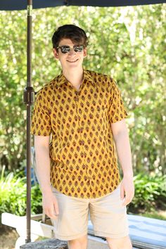 Our Amber Amer Men's shirt is so super soft and such a great colour combination. We have named it after the Amer Fort in Jaipur where this shirt is made. Block printers in Jaipur have practiced this art for centuries. This shirt will be a favourite for the summer! 100% cotton Wash cold, hang dry. Made in India This fabric is block printed by hand so slight variations in printing may exist which demonstrate the hand made aspect of this product. Traditional Cotton Shirt For Festive Season, Traditional Printed Shirt For Festivals, Traditional Printed Yellow Tops, Cotton Ikat Print Short Sleeve Top, Traditional Cotton Camp Shirt With Short Sleeves, Festive Yellow Cotton Top, Traditional Printed Shirt With Relaxed Fit, Traditional Fitted Printed Shirt, Traditional Printed Relaxed Fit Shirt