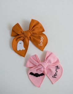 two halloween hair bows with ghost on them