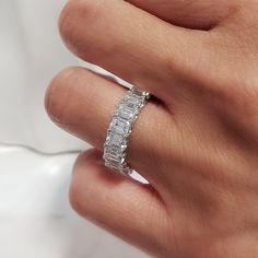 a woman's hand with a diamond ring on top of her finger and the band is white gold