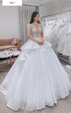 a woman standing in front of some wedding dresses