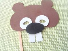 a brown bear mask on top of a toothpick with white strips around it