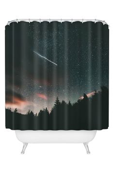 a shower curtain with the night sky and stars above trees in front of an orange glow