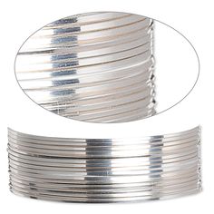 a stack of silver bracelets on a white background