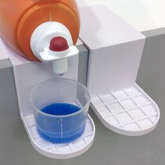 an orange and blue liquid is being poured into a cup