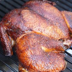 two pieces of cooked chicken sitting on top of a grill