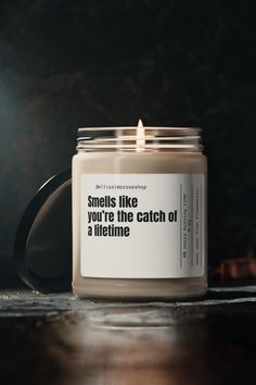 a candle sitting on top of a wooden table next to a bottle with a message