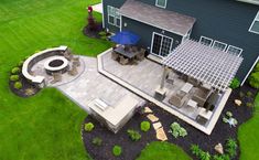 an aerial view of a backyard with patio and fire pit in the middle of it