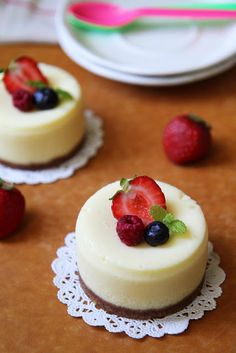 three small cheesecakes with fresh fruit on top