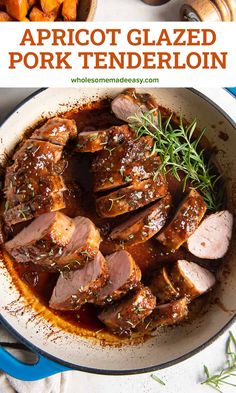 a pan filled with sliced pork and garnished with rosemary on top, next to carrots