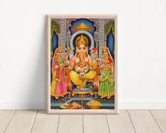 a framed painting of lord ganesha with his family on the floor in front of a white wall