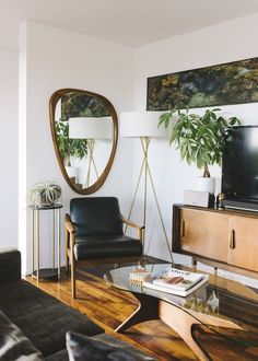 a living room filled with furniture and a flat screen tv sitting on top of a wooden table