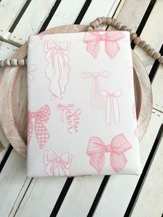 a pink and white pillow with bows on it