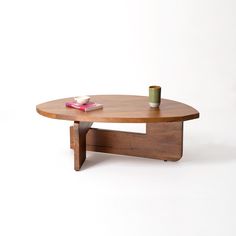 a wooden table with a book on it and a cup sitting on top of it