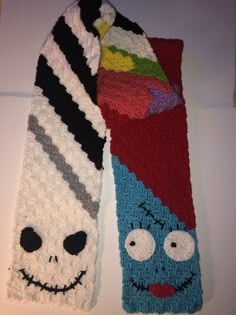 two crocheted scarves with faces on them