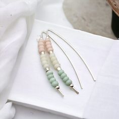 Shine bright with these quirky, playful threader earrings! The Wish - Silver & Pastel earrings feature delicate silver threads adorned with pastel pink, green, and white seed beads. Add a touch of whimsy to any outfit with these unique and stylish earrings. Sterling Silver Approximately 1.5" long Quality Miyuki Seed Beads in pastel pink, green & white Sent in a Ribboned Gift Box with Polishing Cloth Handmade in Montana Pastel Beaded Earrings, Adjustable Pastel Beaded Jewelry, Whimsical Pink Nickel-free Earrings, Nickel-free Pink Beaded Earrings, Handmade Pink 14k Gold-filled Earrings, Pastel Earrings, Stylish Earrings, Key To My Heart, Stylish Earring