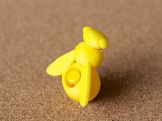 a small yellow toy sitting on top of a brown floor