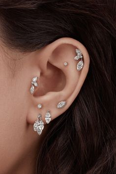 a woman's ear with three small diamonds on it