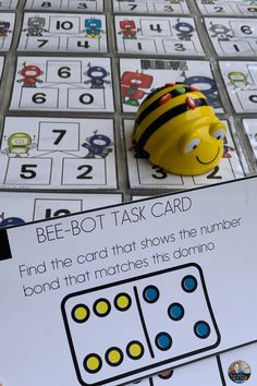 a bee - bot task card is shown on top of a table with matching numbers