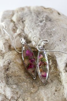 "I just adore these dainty heather marquise drop earrings. So romantic, so whimsical. These are extremely lightweight, and are perfect for you nature lovers. We've carefully preserved these heather sprigs in high quality resin so that they will never wilt or fade. The frame on these are approx 9mmx25mm. The frame is high quality gold or silver plated brass and the fish hooks are safe for sensitive ears. All of our jewelry is nickel free and safe for sensitive ears! Our jewelry comes to you in a Silver Earrings With Pressed Flowers For Wedding, Wedding Pressed Flower Drop Earrings, Silver Wedding Earrings With Pressed Flowers, Wedding Drop Earrings With Pressed Flowers, Wedding Silver Earrings With Pressed Flowers, Dainty Pressed Flower Earrings For Wedding, Delicate Silver Earrings With Pressed Flowers, Fish Hooks, Botanical Jewelry