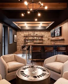 a living room filled with furniture and a bar in the back drop off wall behind it