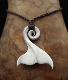 a white necklace with a spiral design on it