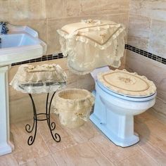 a white toilet sitting next to a sink in a bathroom on top of a tiled floor