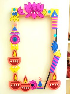 a colorful photo frame with candles and flowers on the front is decorated in bright colors